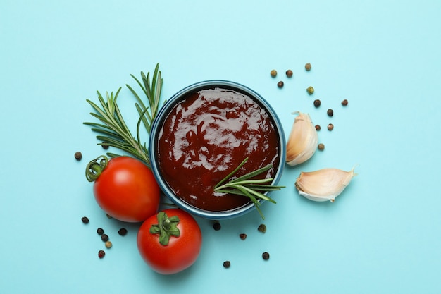 Schüssel Barbecue-Sauce und Gewürze auf blau