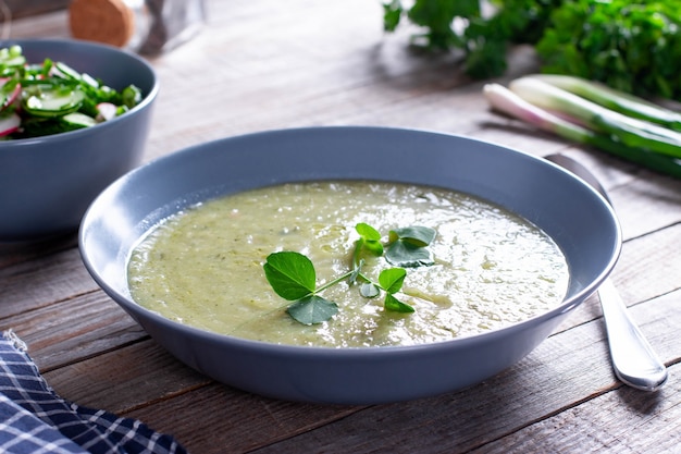 Schüssel Brokkoli und Erbsencremesuppe auf Holztisch, Gemüsesuppe