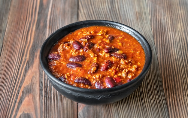 Schüssel Chili mit Fleisch auf einem Holztisch