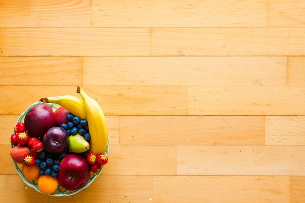 Schüssel frische Frucht mit Bananenapfel-Erdbeeraprikosenblaubeerpflaumen-Vollkorn gabelt Draufsicht