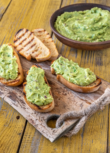 Schüssel frische Guacamole auf rustikalem Hintergrund