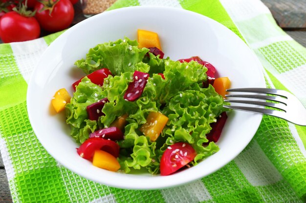 Schüssel frischer grüner Salat auf dem Tisch mit Serviettennahaufnahme