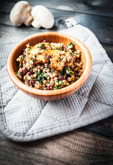 Foto schüssel gekochter buchweizen mit gebratenem champignon, spinat und roten bohnen