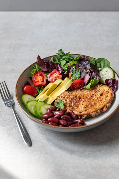 Schüssel grüner Salat mit Scheibe Brot