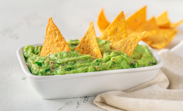 Schüssel Guacamole mit Tortillachips auf dem Tisch