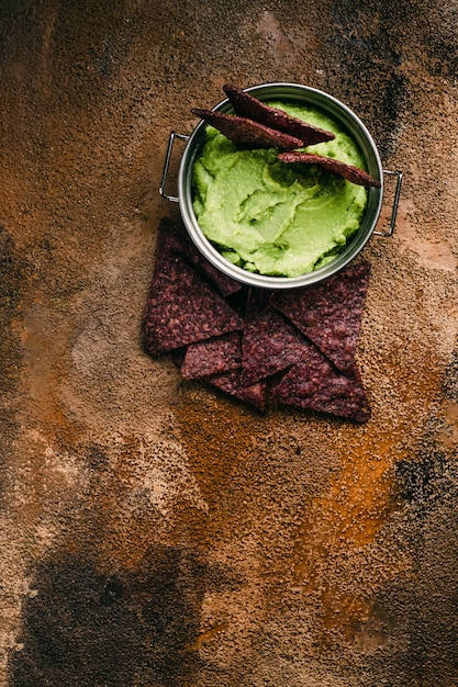 Schüssel Guacamole und Nachos auf hölzernem Hintergrund. Draufsicht