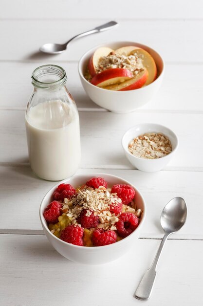 Schüssel Haferbrei mit Himbeeren und Schüssel Haferbrei mit Äpfeln