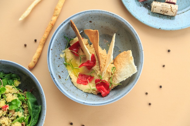 Schüssel hausgemachten Hummus Pastell Hintergrund aus der Draufsicht