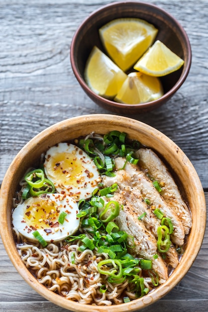 Schüssel Hühnchen-Ramen-Suppe auf dem Holztisch