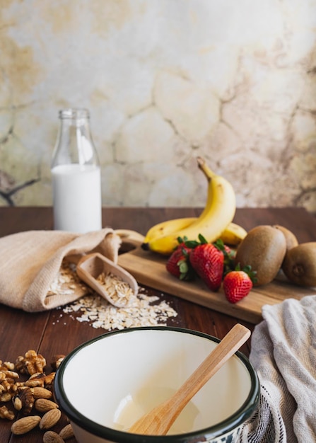 Schüssel im Vordergrund Frühstücksflocken mit Nüssen, Haferflocken und Obst, gesunder Lebensstil