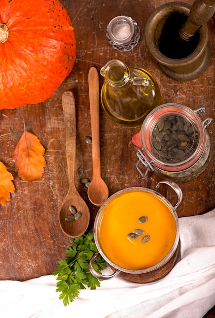 Schüssel Kürbissuppe auf rustikalem hölzernem Hintergrund.