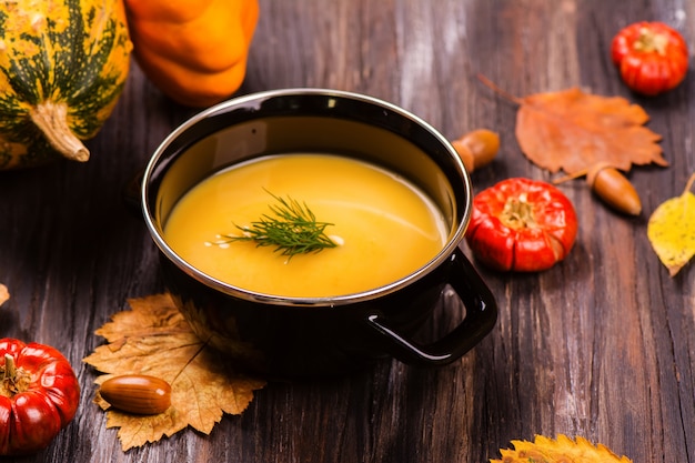 Schüssel Kürbissuppe über Holztisch