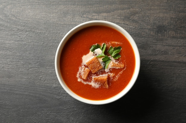 Schüssel leckere Tomatensuppe auf dunklem Holz