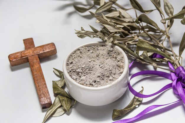 Foto schüssel mit asche olivenzweig und kreuz symbole von asche mittwoch