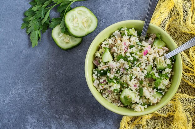 Schüssel mit Couscous-Gurken-Petersilie und Sonnenblumenkernen