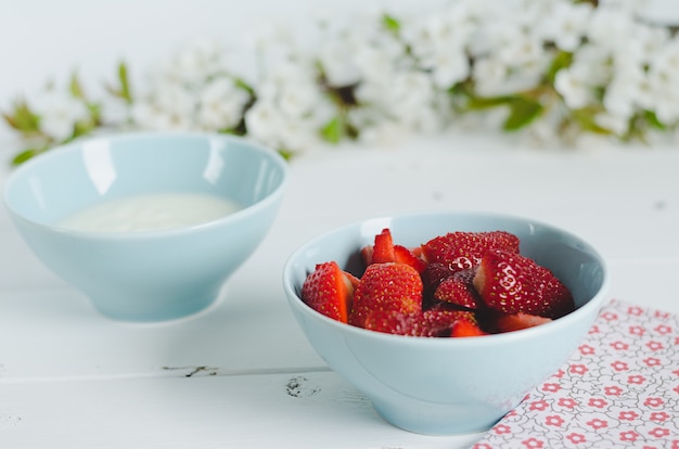 Schüssel mit Erdbeeren auf hölzernem Hintergrund.