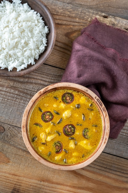 Schüssel mit gelbem Pilzcurry auf dem Holztisch