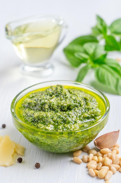 Schüssel mit italienischer grüner Pesto-Sauce aus Basilikumblättern, Olivenöl, Pinienkernen und Parmesan auf dem Tisch