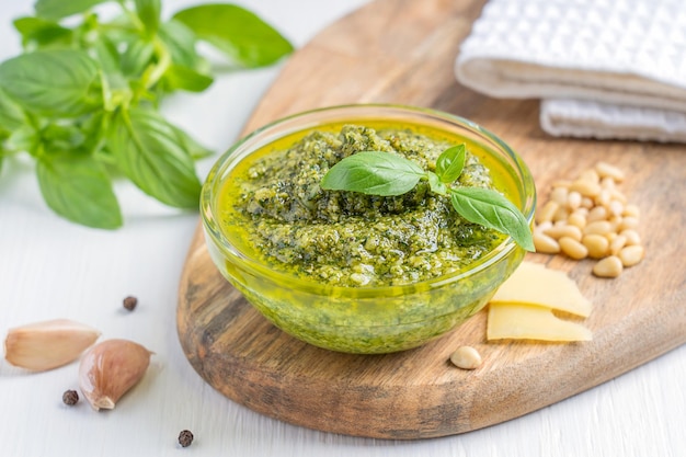 Schüssel mit italienischer Kräuter-Pesto-Sauce aus Basilikumblättern, Pinienkernen, Parmesan und Olivenöl auf dem Tisch