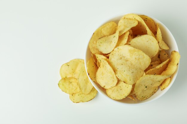 Schüssel mit Kartoffelchips auf weißer Oberfläche