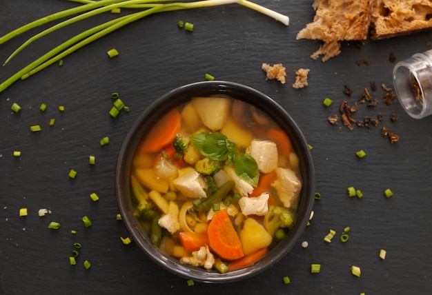 Schüssel mit köstlicher Truthahnsuppe auf schwarzem Hintergrund