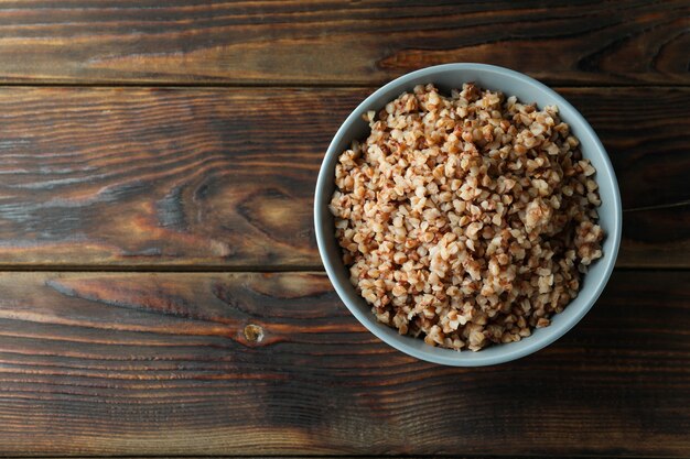 Schüssel mit leckerem Buchweizen auf Holztisch