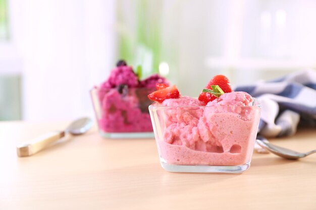Schüssel mit leckerem Erdbeere-Joghurt-Eiscreme auf dem Tisch