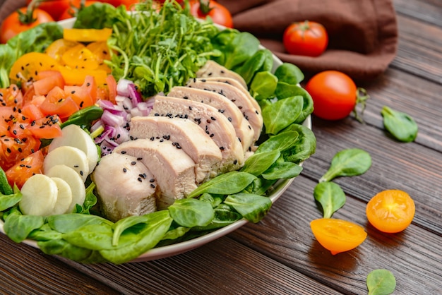 Schüssel mit leckerem Salat auf Holztisch