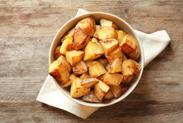 Schüssel mit leckeren Kartoffelecken auf dem Tisch