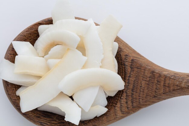 Schüssel mit leckeren Kokoschips auf hellem Hintergrund.