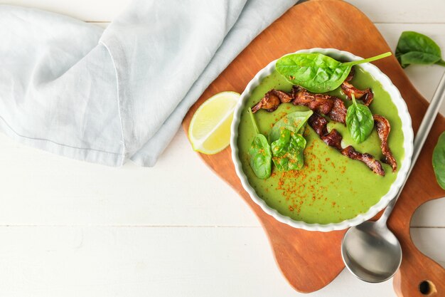 Schüssel mit leckerer Spinatsuppe auf Licht