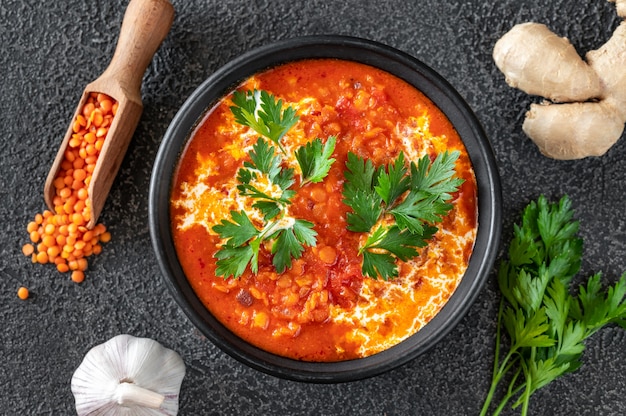 Schüssel mit Linsen-Tomaten-Kokos-Suppe flach liegen