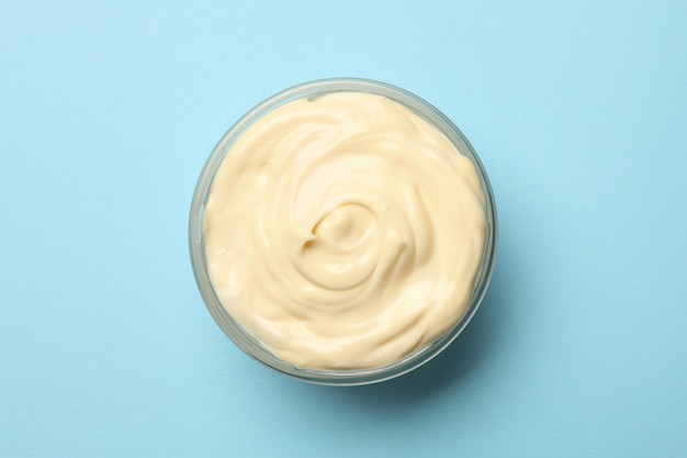 Foto schüssel mit mayonnaise-sauce auf blauem hintergrund