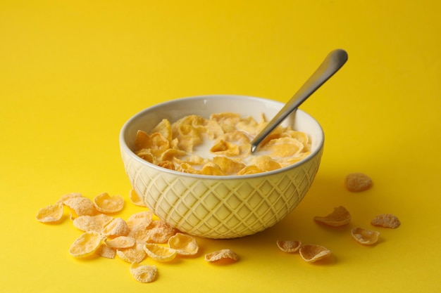 Schüssel mit Müsli und Milch auf gelb