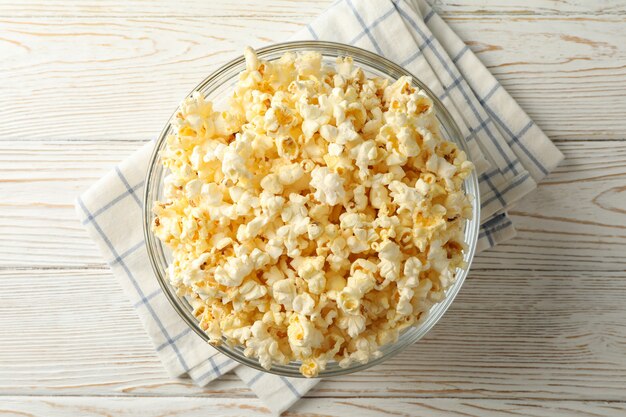 Schüssel mit Popcorn auf weißem Holz.