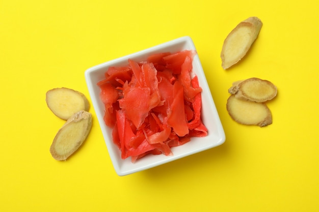 Schüssel mit rot eingelegtem Ingwer auf gelber Oberfläche