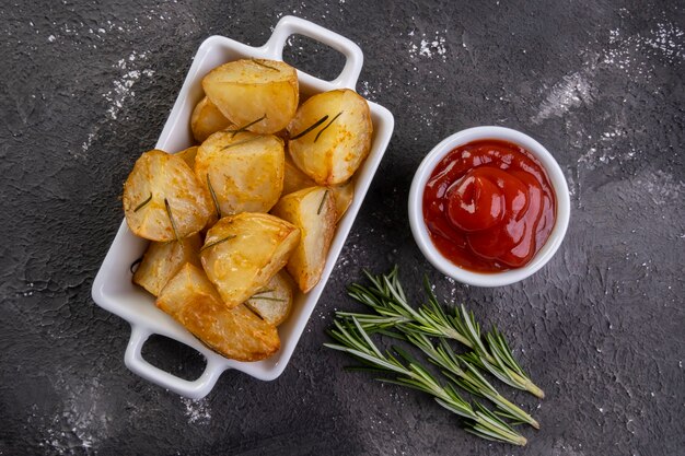 Schüssel mit rustikalen Brat- und Bratkartoffeln mit Rosmarin.