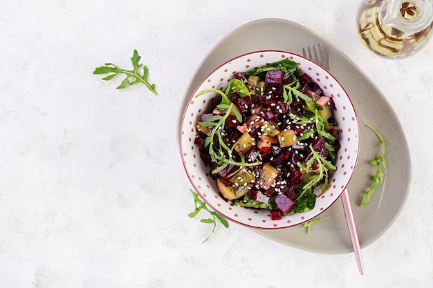 Schüssel mit Salat mit gebackener Rote Beete Kiwi Spinat Rucola und Dressing Senföl Draufsicht flach liegend