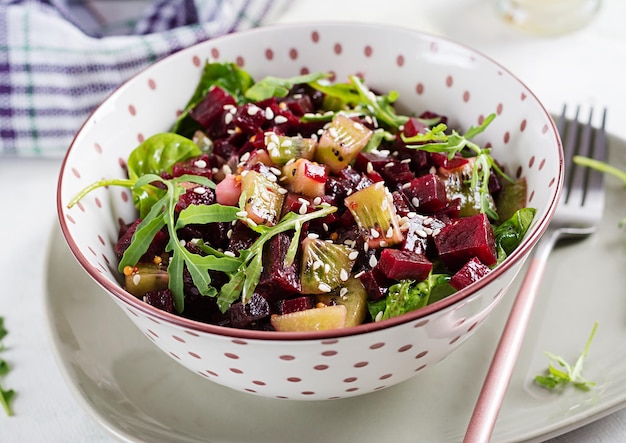 Schüssel mit Salat mit gebackener Rote Beete Kiwi Spinat Rucola und Dressing Senföl