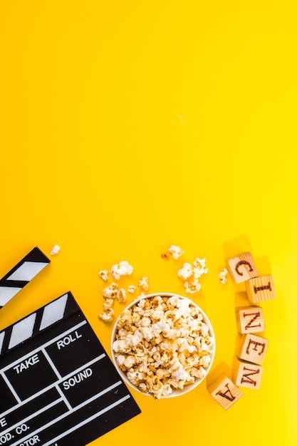 Foto schüssel mit salzigen popcorns auf gelbem hintergrund. kino-snack-konzept. ansicht von oben flach liegen