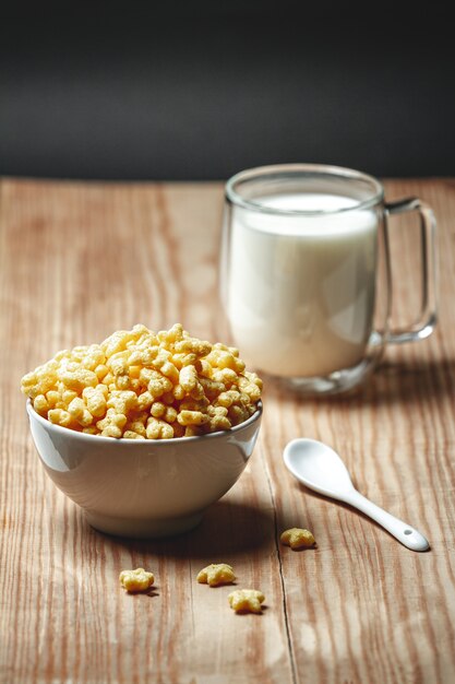 Schüssel mit schnellem Frühstücksflocken und einem Glas Milch