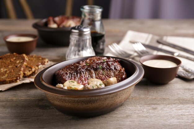 Schüssel mit Steak Diane auf Holztisch