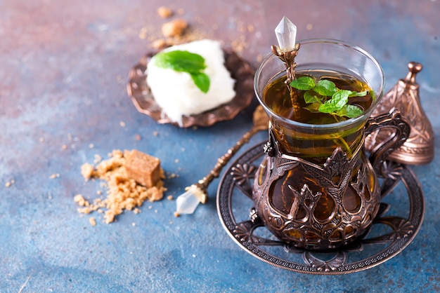 Schüssel mit türkischer Zuckerwatte Pismaniye und schwarzem Tee mit Minze