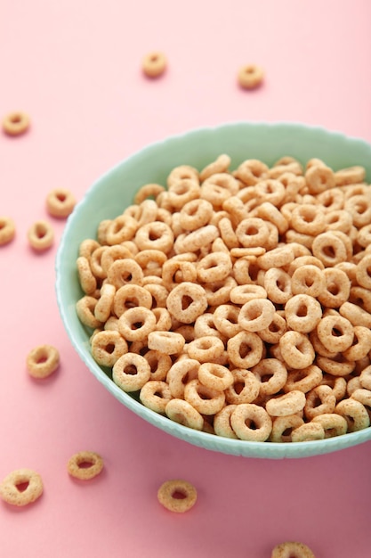 Schüssel mit Zucker überzogene Cornflakes auf rosa Hintergrund