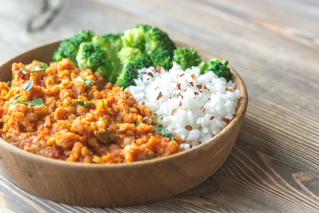 Schüssel rotes Linsencurry mit weißem Reis und Brokkoli