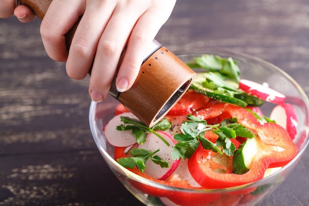 Schüssel Salat mit Gemüse und Gemüse auf Holztisch