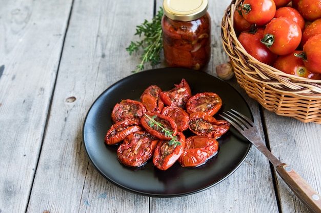 Foto schüssel sonnengetrocknete tomaten auf hölzernem hintergrund. sonnengetrocknete tomaten mit olivenöl und kräutern