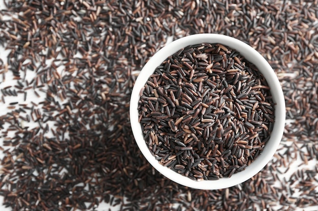 Schüssel und Haufen roher Wildreis auf dem Tisch