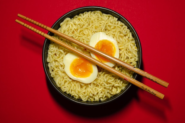 Schüsseln mit Ramen-Suppe mit Eiern und Essstäbchen. Instant-Nudeln.