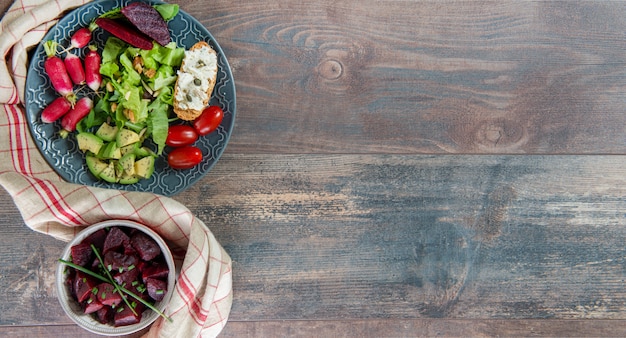 Schüsseln und Teller mit gesunden veganen Salat